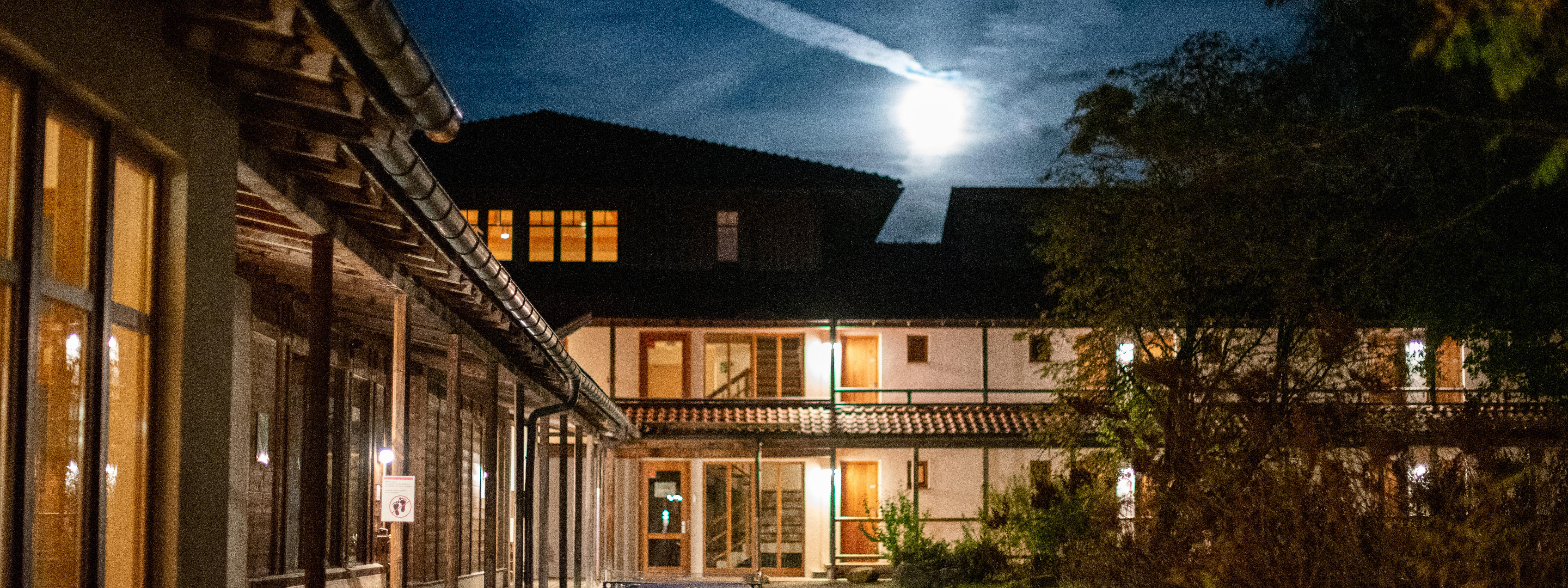 ZIST in der Nacht mit Vollmond über dem Seminarhaus und beleuchteten Fenstern