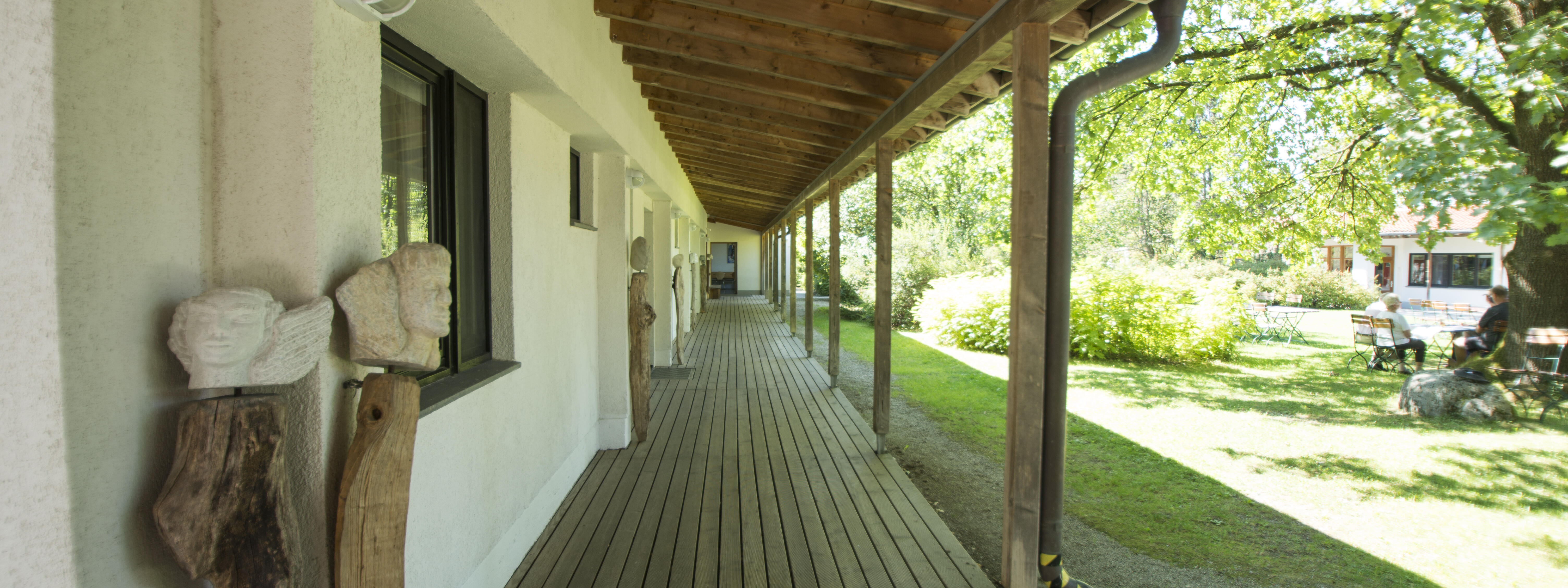 ZIST Aussengang mit Steinskulptur im Sommer