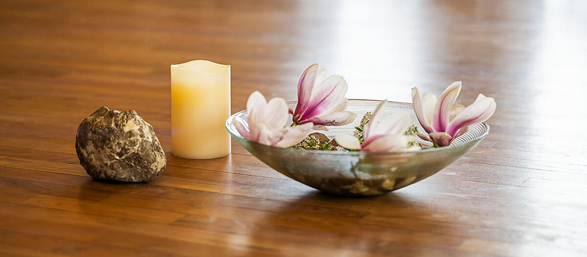 Blumenschale mit Magnolien, Stein und Kerze im Saal by EM