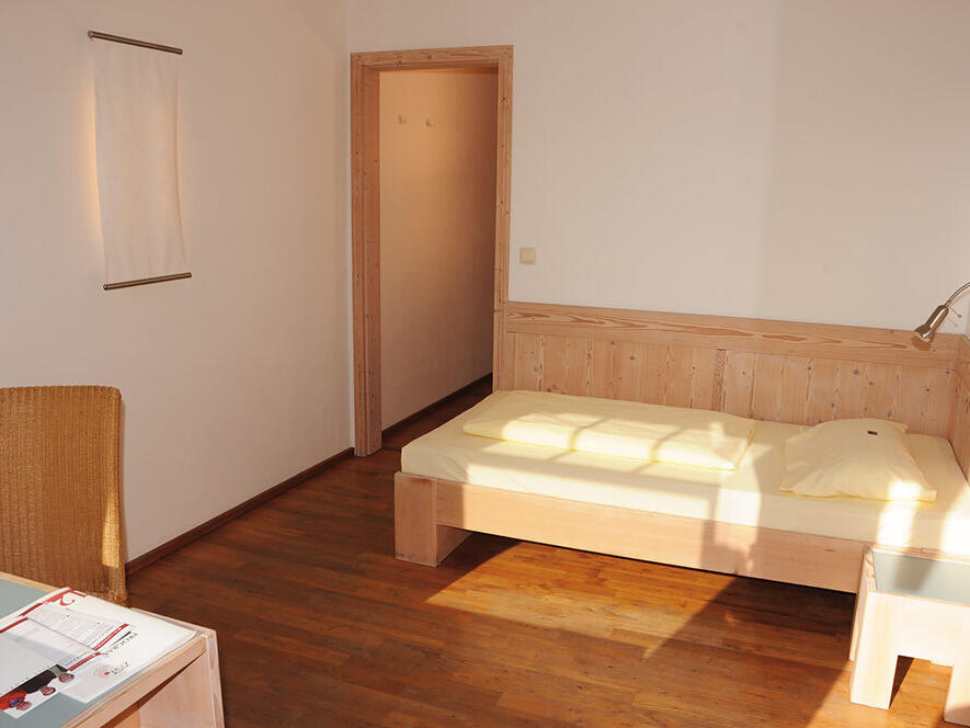 ZIST Unterkunft im Neubau, Sonne schein auf das Bett und den Tisch